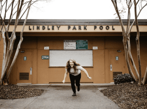 Image of women being excited for therapy, the women is coming out of a building excited to heal